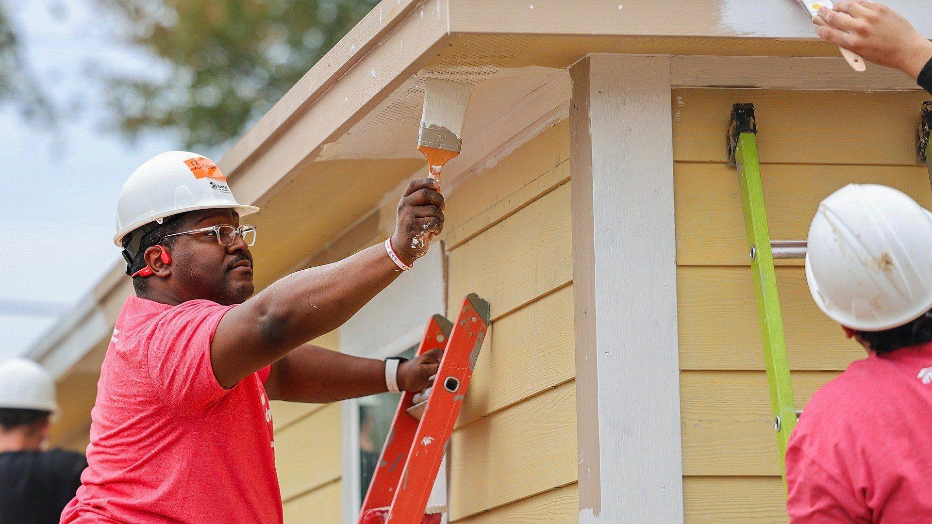 Volunteer painting house siding 2